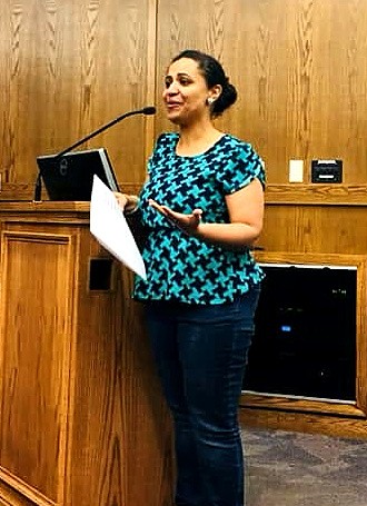 Luciana Paulino speaking at a podium